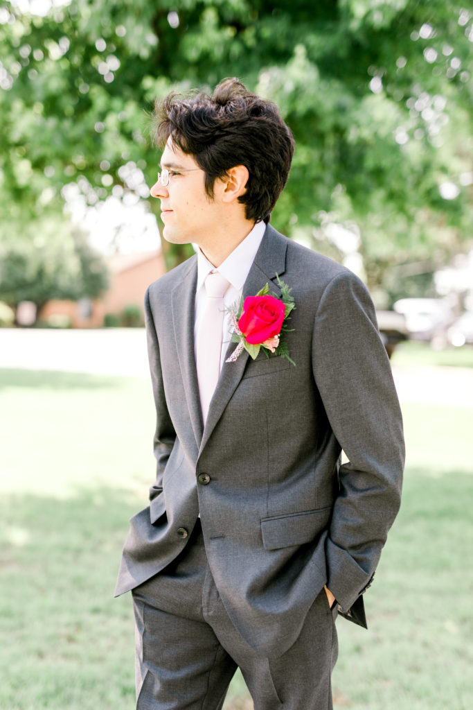 Groom looking to the side, hands in pockets