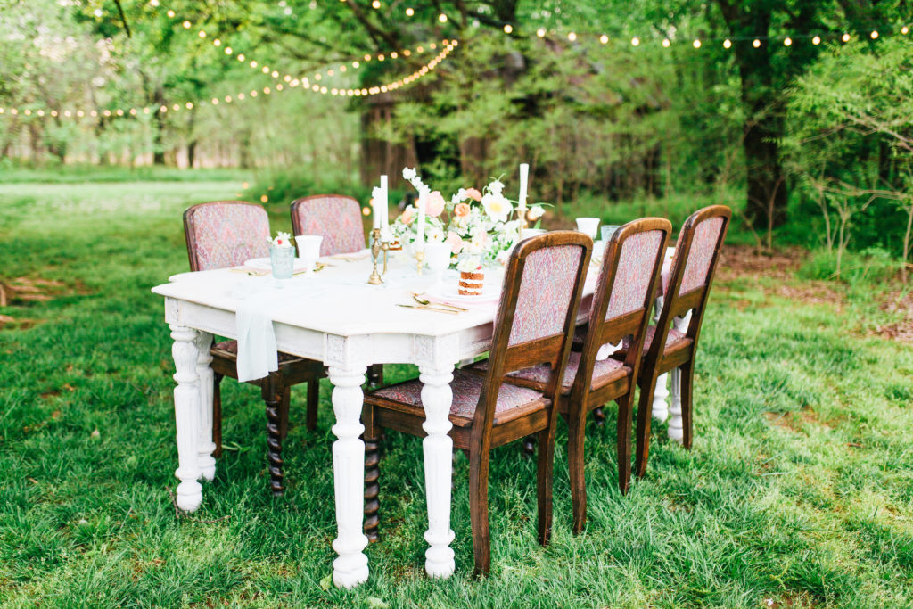 Table on the lawn with wedding settings - The barn at the woods wedding venue